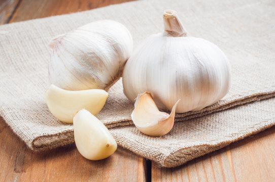 Organic garlic whole and cloves on the wooden background