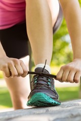 Fit woman tying her shoelace