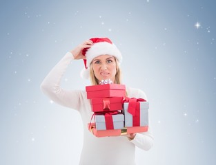 Confused blonde in santa hat holding gifts