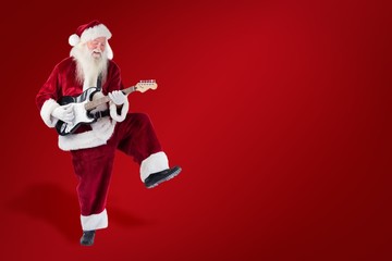Composite image of santa claus has fun with a guitar