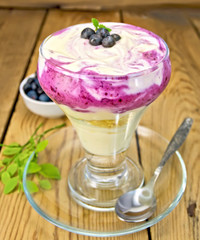 Dessert milk with blueberries in glassware on board