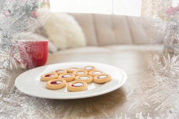 Composite image of cookies and mug on coffee table at christmas