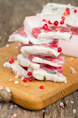 salted lard and spices on wooden surface