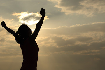 Fototapeta premium strong confidence woman open arms under the sunrise at seaside 