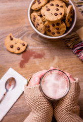 Female hands with hot drink and chocolate cookies