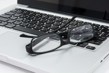 Blank business laptop, mouse and glasses