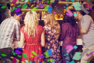 Composite image of happy friends having a drink together