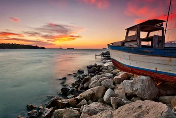 Poster de jardin Mer / coucher de soleil Sunset view with an old boat at the Black sea coast