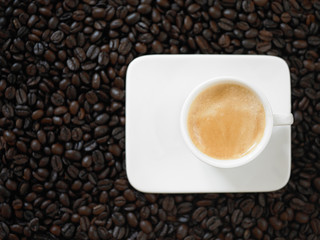 A cup of cafe latte with coffee beans