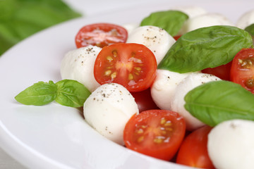 Caprese Salat mit Tomaten, Basilikum und Mozzarella auf Teller