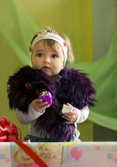 child holding two small gifts and standing in the box