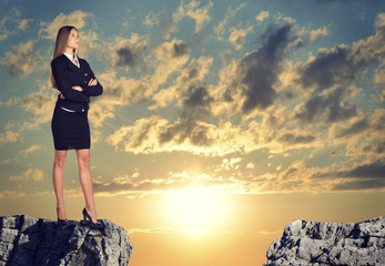 Businesswoman standing on the edge of rock gap