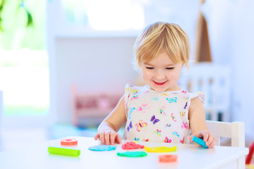 Preschooler girl playing with plasticine