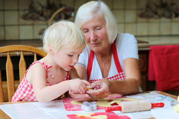 Grandma and granddaughter making cookies together