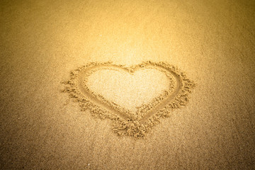 Heart drawn in the sand. Beach background. Tinted