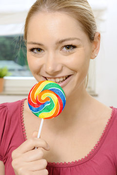 Blonder Twen mit buntem Lolli