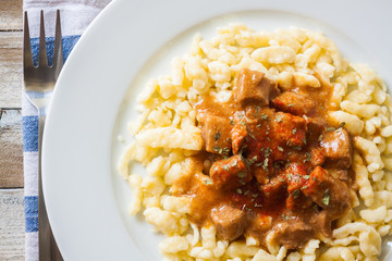 Hungarian goulash of veal with dumplings, top view, closeup
