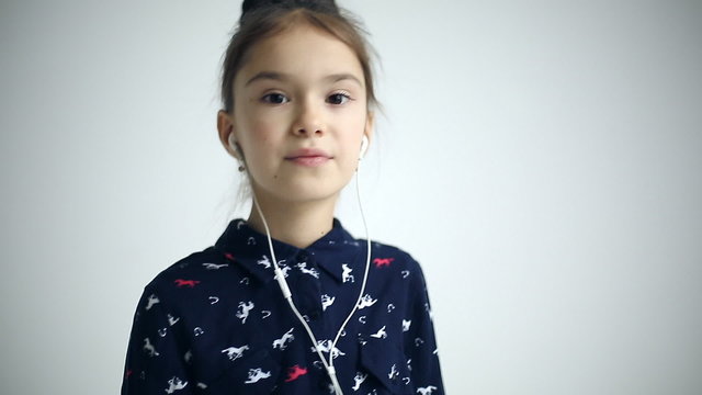 Child with earflaps dancing at studio background