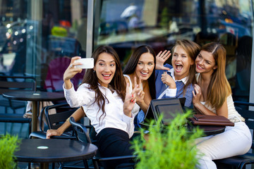 Four women sitting in a cafe on the street