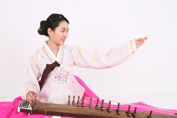 가야금을 뜯는 한복 입은 여성
