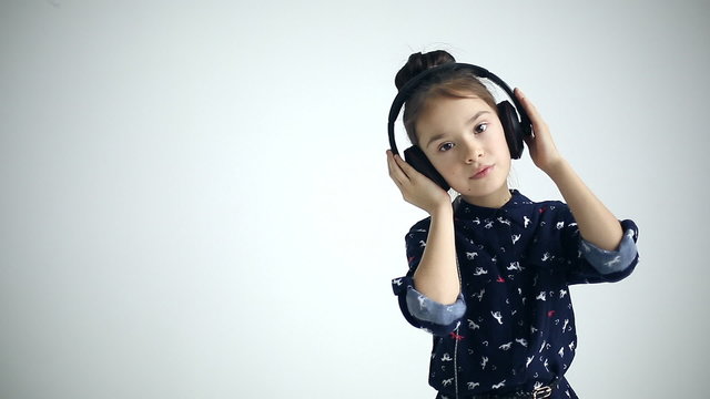 Child with headphones dancing at studio background