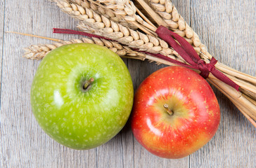 apples and wheat cobs placed on a wooden table