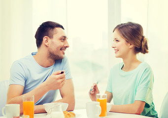 Fototapeta na wymiar smiling couple having breakfast at home
