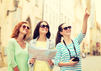 smiling teenage girls with map and camera