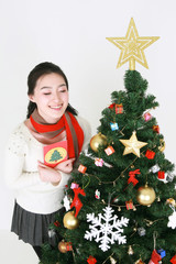 크리스마스 트리 옆의 젊은 한국 여성