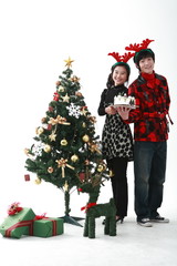 크리스마스 트리 옆에 있는 젊은 사람들