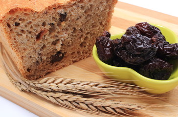 Baked wholemeal bread, dried plums and ears of wheat