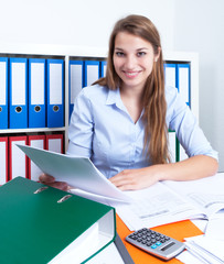 Frau mit langen blonden Haaren mit Brief im Büro © Daniel Ernst