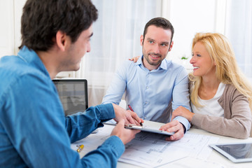 Obraz premium Young attractive couple signing contract