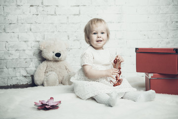 Little girl with bright red jewelery posing on brick background - 74985126