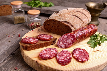 Sliced salami and bread on a cutting board