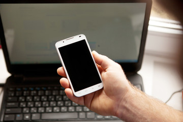 Man using smartphone, close-up, notebook on the background