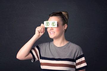 Young girl holding paper with green dollar sign