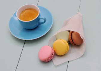 Macarons in backing paper cornet and blue Espresso cup