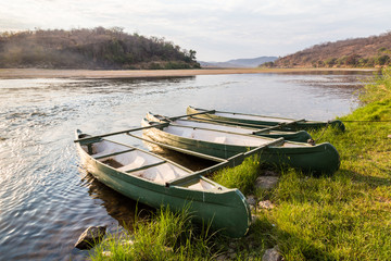 Obraz premium Rowing boat lying on the banks of a river lit by sun
