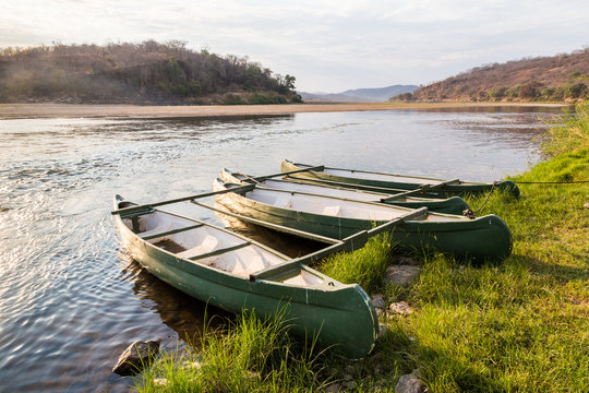 Rowing boat lying on the banks of a river lit by sun