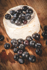 Smelly blue cheese on a wooden rustic table with blueberries