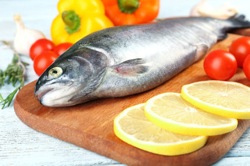Fresh raw fish and food ingredients on table
