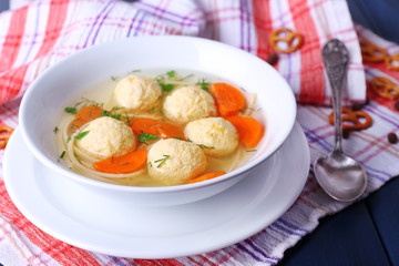 Soup with meatballs and noodles in bowl on wooden background
