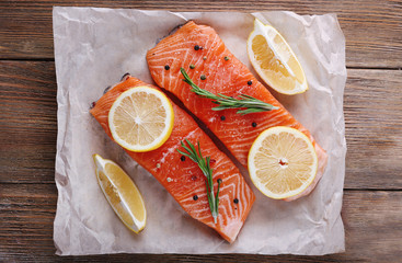 Fresh salmon with spices and lemon on wooden table