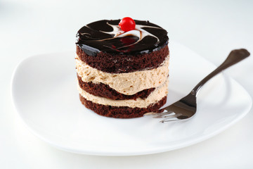 Yummy chocolate cupcake on white plate, close-up
