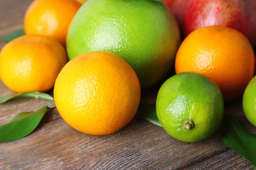 Ripe citrus with green leaves on wooden background