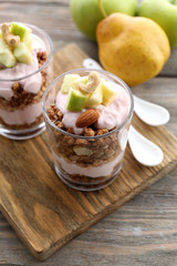 Healthy layered dessert with muesli and berries on table