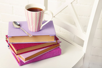Naklejka premium Pile of books with cup and spoon