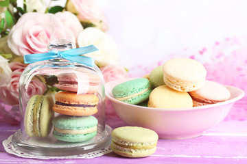 Gentle colorful macaroons in glass bell jar and milk glass