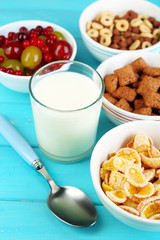 Various sweet cereals and berries in ceramic bowls and glass